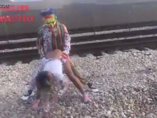 Clown baise écolière sur train tracks